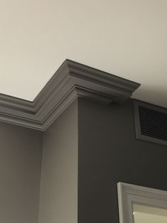 the corner of a room with a ceiling vent and mirror on it's side