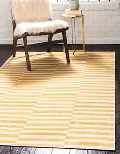 a yellow and white rug with a wooden chair