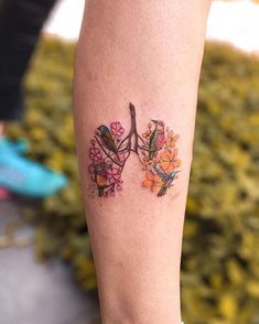 a woman's leg with flowers and birds on it