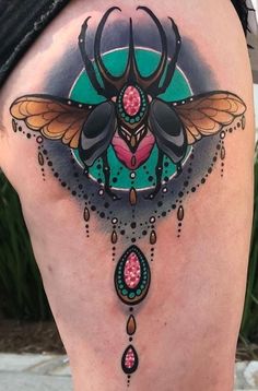 a woman's thigh with an insect tattoo on it