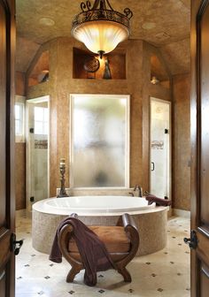 a bathroom with an oval tub and chandelier above the bathtub is seen on instagram