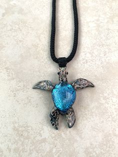 Diamond of the Sea Turquoise Sea Turtle pendant with vibrant blue like the ocean. It is our larger version as we have one that is a little bit smaller at the following link: https://www.etsy.com/listing/168653185/sea-turtle-necklace-dainty-jewelry-gift This glass sea turtle pendant necklace is about 2 inches long. This is a beautiful pendant or could be used as beach jewelry or be given as a gift to a diver. It comes mounted on a soft adjustable blackpendant cord that extends from about 16 inche Blue Pendant Jewelry For Beach, Adjustable Blue Ocean-inspired Necklace, Adjustable Blue Necklace For Vacation, Unique Blue Jewelry For The Beach, Unique Blue Jewelry For Vacation, Blue Spiritual Jewelry For Vacation, Adjustable Turquoise Ocean-inspired Necklace, Adjustable Turquoise Ocean-inspired Necklaces, Beach Turquoise Glass Jewelry