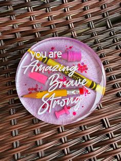 a pink paper plate with some crayons on it that says you are amazing