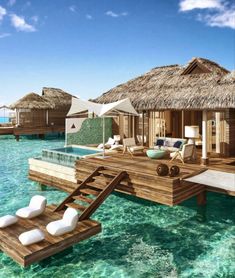 an over water resort with thatched huts on stilts and lounge chairs in the water