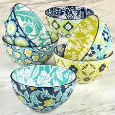 four colorful bowls sitting on top of a marble counter