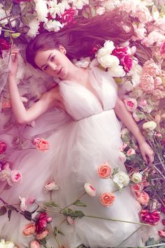 a woman in a white dress surrounded by flowers