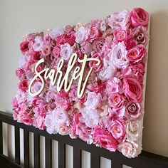 a pink and white flowered wall with the word sweet spelled in gold lettering on it