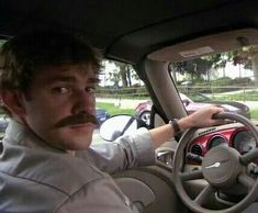 a man sitting in the driver's seat of a car