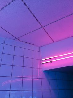 there is a purple light in the corner of this bathroom stall that says, little one killjoys