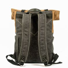 the back view of a grey backpack with brown trims and two zippers on each side