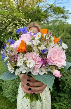 a woman holding a bouquet of flowers in her hands