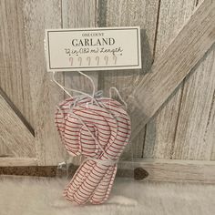 candy canes wrapped in red and white striped paper are tied to a wooden door