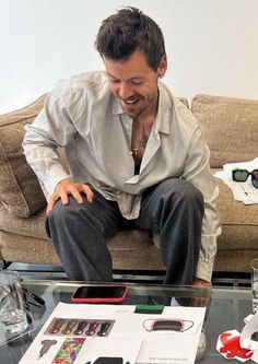 a man sitting on top of a glass table