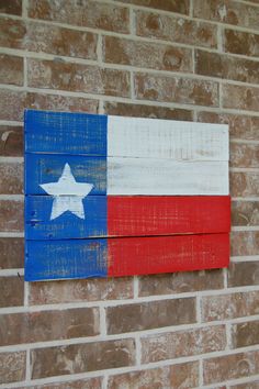 the texas flag is painted on wood planks in front of a brick wall with a red, white and blue sign