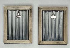 two wooden frames with metal clips in them on a white wall next to each other