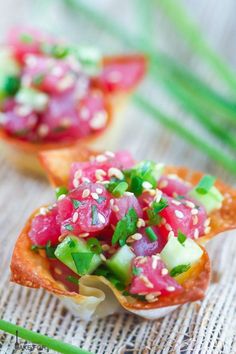 small appetizers with cucumber, radishes and sesame seeds on them