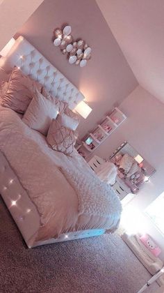 a bedroom with a large bed and lots of lights on the headboard in it