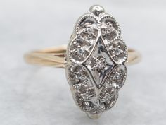 an antique diamond ring is shown on a white surface with gold accents and diamonds in the center