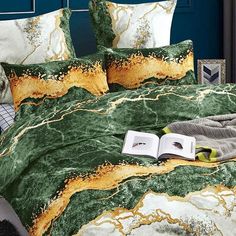 a bed with green and gold marbled comforter set on top of the bed