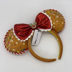 a minnie mouse ears headband with a red bow and sequins on it