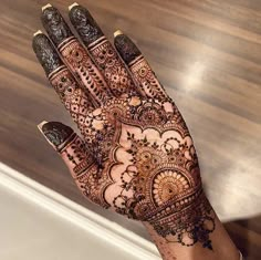 a woman's hand is decorated with hennap and intricate designs on it