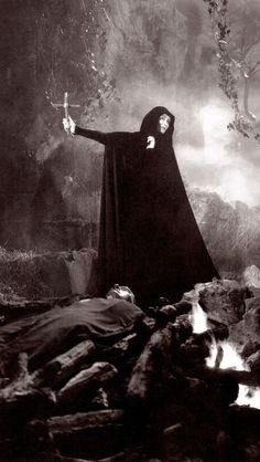 an old black and white photo of a woman in a nun costume with her arms outstretched