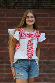 UofH, Houston Rockets, Texas Tech, SMU  Mexican Women's Shirt, white with full red embroidery. New fashionable ruffled sleeves. Beautiful, authentic custom shirt, made by artists in Mexico. Perfect game day attire! Made with lightweight manta cotton fabric, floral embroidery, short ruffled sleeves and a great and easy fit.  Colors and design may vary slightly as these are hand made Care:  For best care we suggest you hand wash Casual Embroidered Short Sleeve Top, Casual Tops With Embroidered Short Sleeves, Casual Top With Embroidered Short Sleeves, Casual Red Blouse With Flutter Sleeves, Casual Blouse With Floral Embroidery And Ruffle Sleeves, Casual Tops With Floral Embroidery And Ruffle Sleeves, Embroidered Ruffle Sleeve Summer Tops, Embroidered Ruffle Sleeve Tops For Summer, Casual Red Tops With Flutter Sleeves