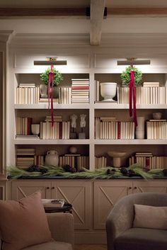 a living room filled with lots of furniture and bookshelves covered in christmas decorations