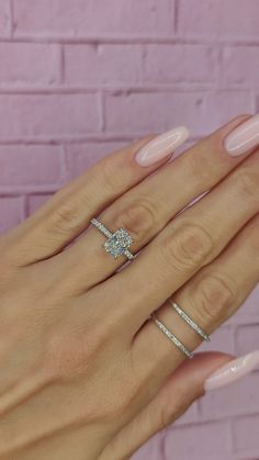 a woman's hand with two rings on her fingers and one ring in the middle