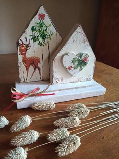 some pine cones are sitting on a table next to paper houses and other items that have been made out of wood