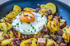 an egg on top of potatoes in a blue bowl