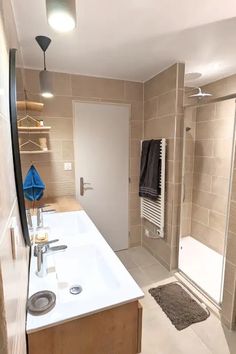 a bathroom with a sink, shower and towel rack