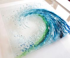 a glass plate with blue and green paint on it