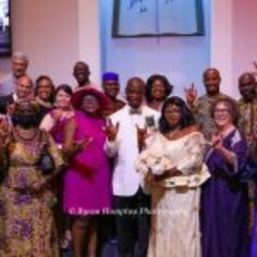 a group of people standing next to each other in front of a church alterp