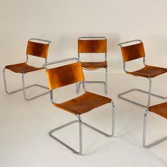 four chairs with wooden seats and metal legs