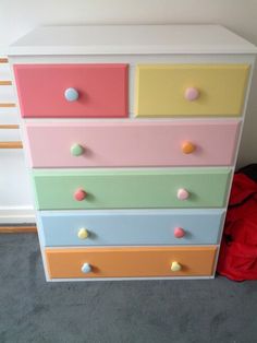 a multicolored dresser with polka dot knobs on the top and bottom drawers