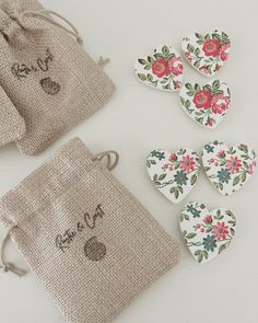 three pieces of fabric with flowers and hearts on them sitting next to a drawstring bag