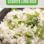 a bowl filled with white rice and cilantro on top of a wooden table