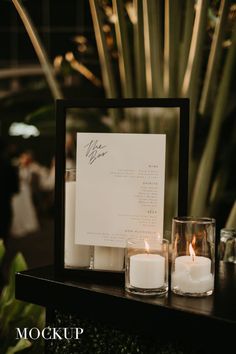 two candles are sitting on a table next to a menu