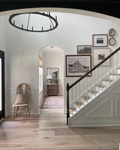 an entry way with stairs and pictures on the wall