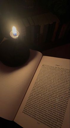 an open book with a lit candle sitting on top of it