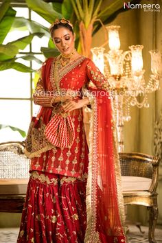 Endearing Pakistani Gharara Online For Wedding Party is chic and sophisticatedly designed in old techniques embroidered in dabka, tilla, zari thread work. Wedding Pakistani sharara suit is itself a charm with its intricate emblazoned work. The combination of red and golden working on the complete dress is completely breathtaking. Compliment the look with gajra on hair with intricate jewelry and be ready to flaunt beauty at your wedding festive. Shirt: Beautiful intricate designed shirt with ghar Elegant Naqshi Sharara For Festivals, Festive Naqshi Sharara, Festive Eid Sharara With Naqshi Detailing, Traditional Drape Sharara With Naqshi For Festive Occasions, Naqshi Sharara For Reception With Traditional Drape, Festive Gold Sharara With Naqshi Details, Anarkali Sharara With Naqshi For Reception, Traditional Naqshi Sharara For Reception, Traditional Naqshi Sharara For Festive Occasions