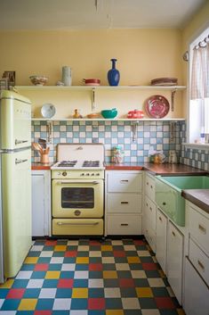 an old fashioned kitchen with colorful floor tiles