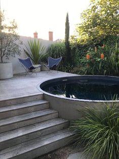 an outdoor hot tub in the middle of a garden with steps leading up to it