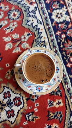 a cup of coffee sitting on top of a rug