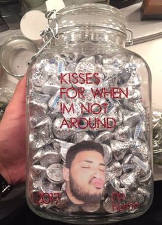 a glass jar filled with lots of chocolates and a man's face on it