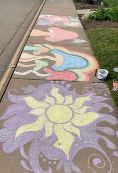 the sidewalk is painted with colorful chalk and flowers