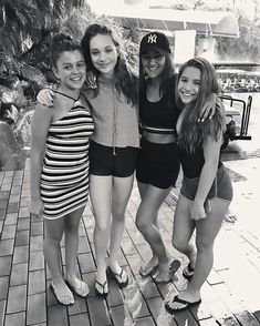 four girls are posing for the camera in their bathing suits