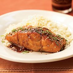 a white plate topped with salmon and rice