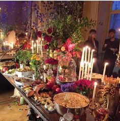 a buffet table with candles and flowers on it